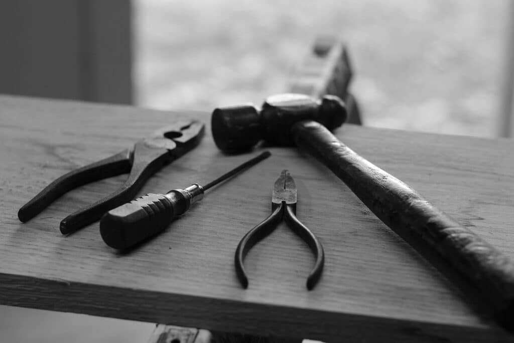 Black and white close-up of hand tools on a bench, representing Peavey Mart closures across Canada