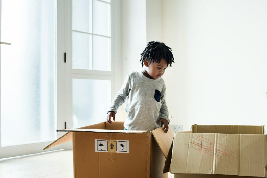 a young child standing in a moving box