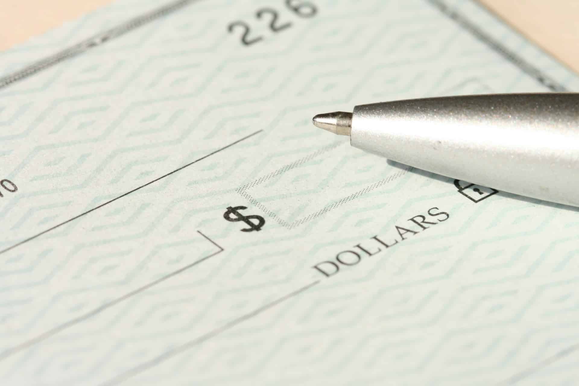 a pen sitting on top of a blank cheque