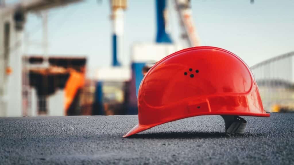 A red hard hat on the pavement, representing the Rand Formula.