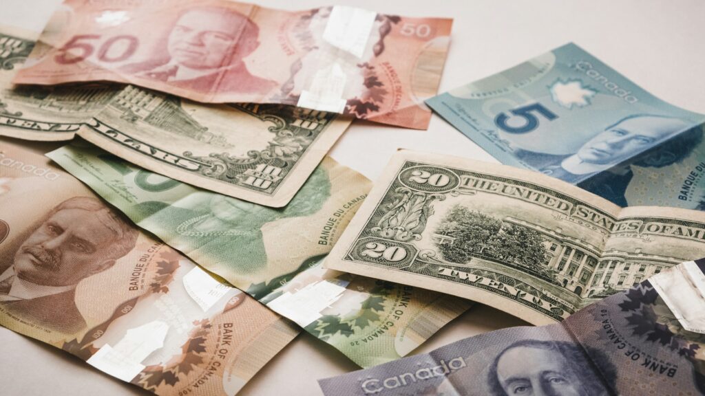 a pile of canadian and american money on a counter top
