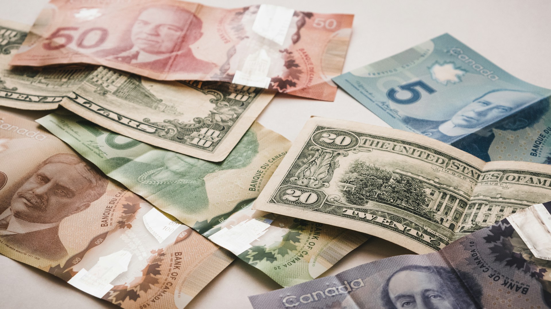 a pile of canadian and american money representing crowdfunding - Calgary crowdfunding business lawyers