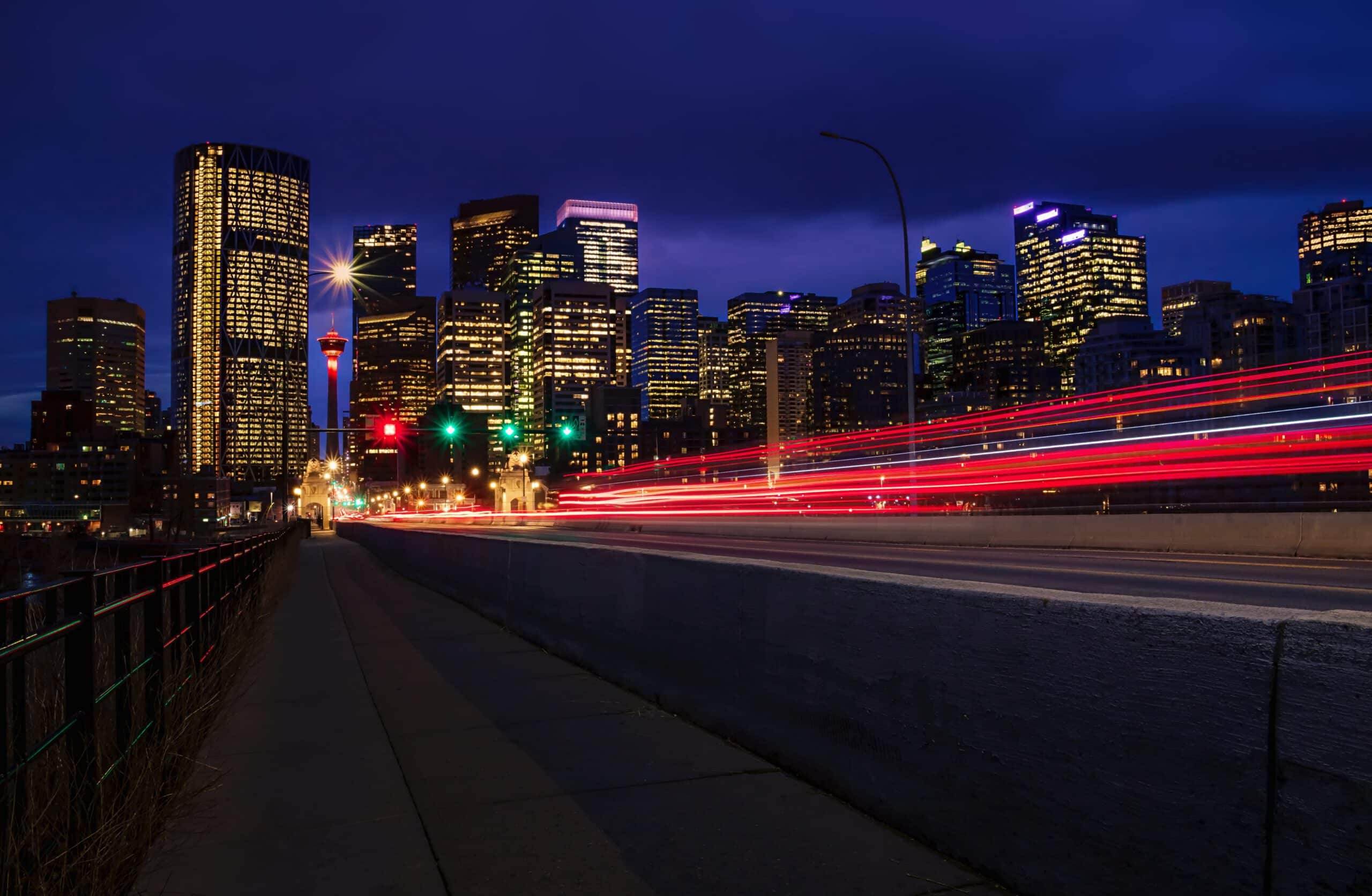 Long-exposure view of car headlights streaking toward the downtown Calgary skyline, representing Criminal Law in Calgary and Strathmore, Alberta.