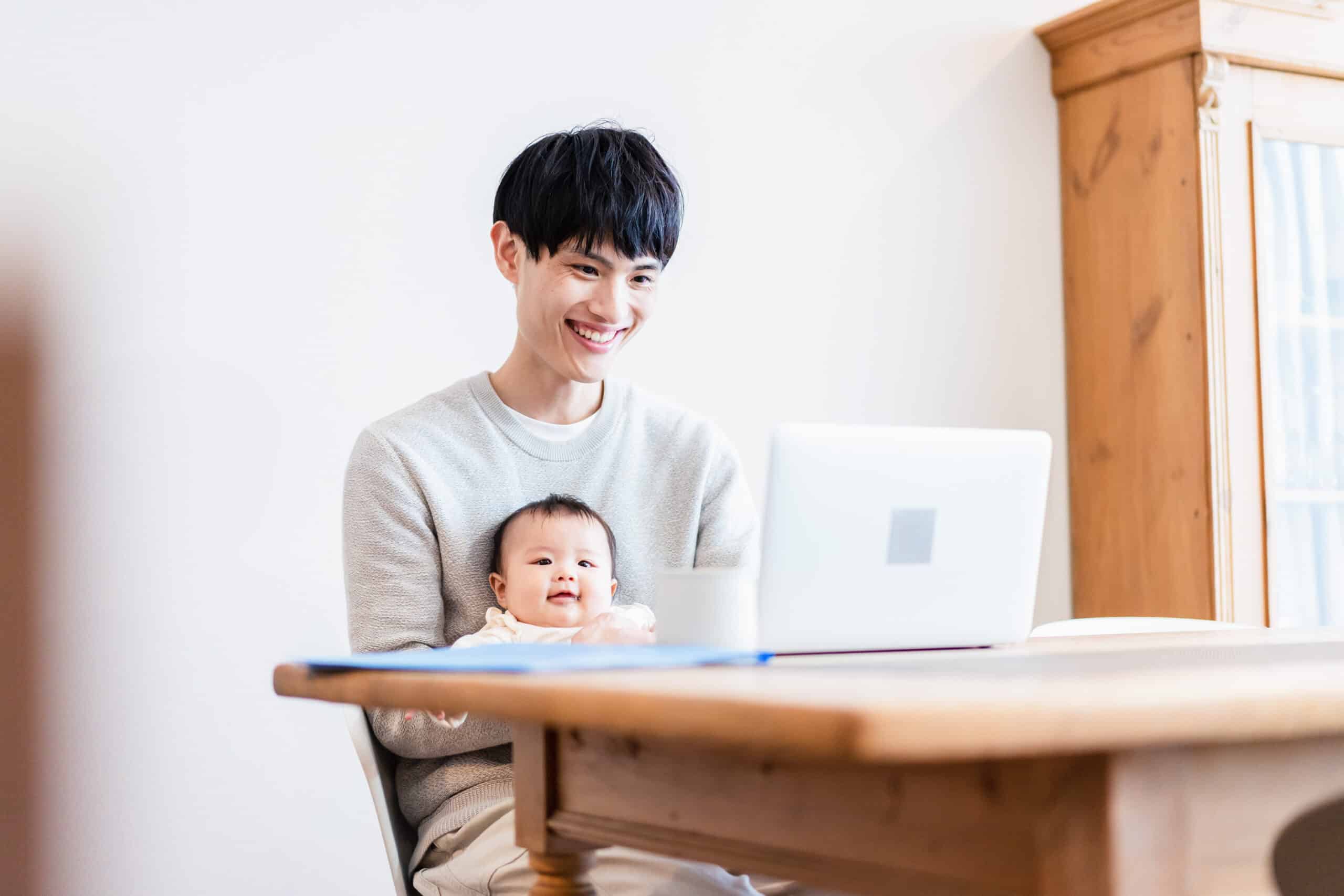 A young parent sitting on a Zoom call with their baby in their lap, representing Parental Leaves in Calgary, Alberta.
