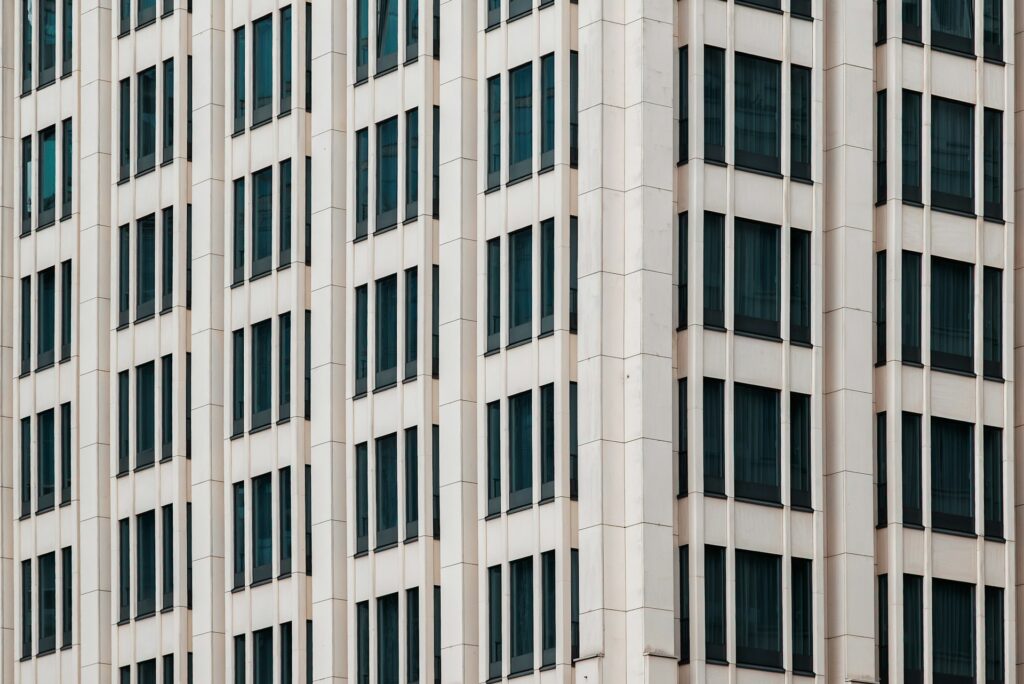 The side of a concrete office building with rows of long dark windows, representing non-compete and non-solicitation clauses.