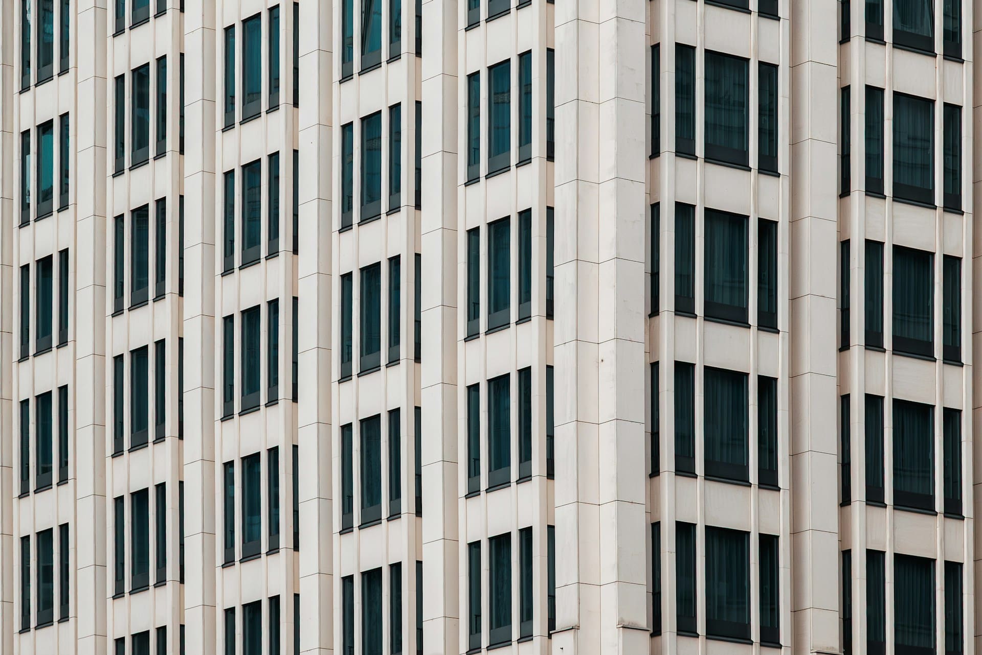The side of a concrete office building with rows of long dark windows, representing non-compete and non-solicitation clauses.