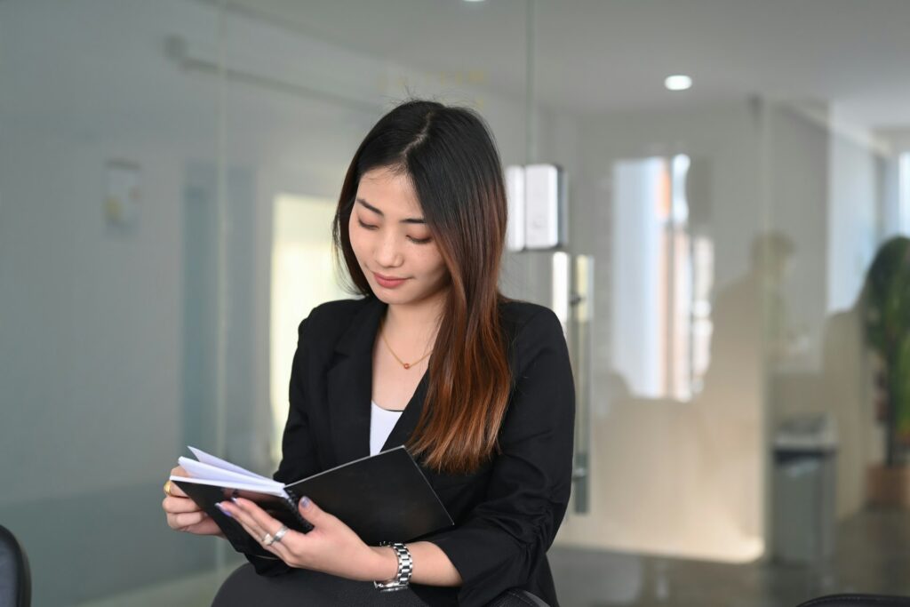 A young woman reviewing a notebook, representing employee handbooks and the importance of workplace policies for Alberta employers